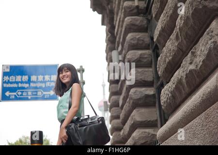 Young businesswoman,smiling, outdoors, Shanghai, China Stock Photo