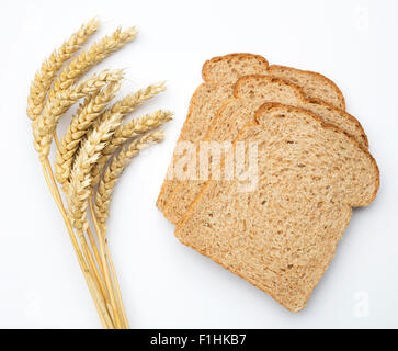 Wheat ears (triticum) and brown bread isolated on white background. Stock Photo