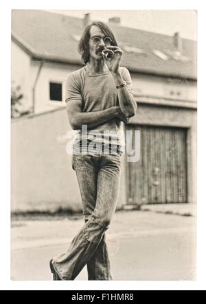 Vintage photo from young fashion smoking man wearing typical 1970s clothing. Stock Photo