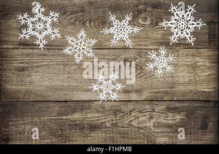 Christmas decoration snowflakes on grunge rustic wooden background. Retro style toned picture Stock Photo