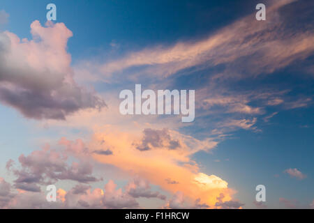 Dramatic colorful cloudscape, summer evening sky background texture with different types of clouds in the sunlight Stock Photo