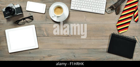 Accessories and digital gadgets for man. Tablet pc, keyboard, camera, phone and coffee on wooden table. Stock Photo