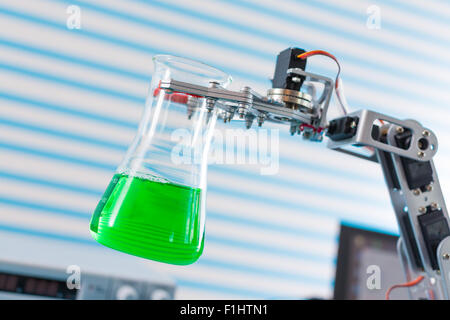 chemical flask in robot arm Stock Photo