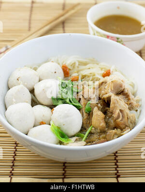 Pork balls and pork boiled noodle in a white bowl with chopsticks Stock Photo