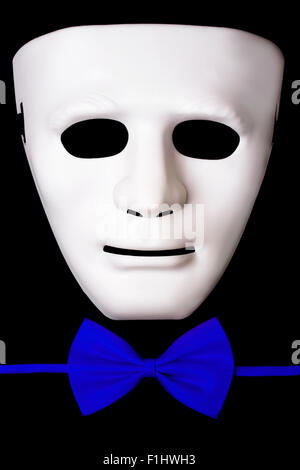 White mask and blue bow tie isolated on black background Stock Photo