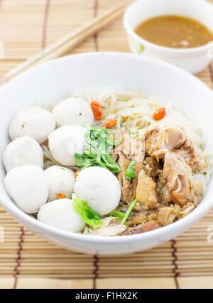 Pork balls and pork boiled noodle in a white bowl with chopsticks Stock Photo