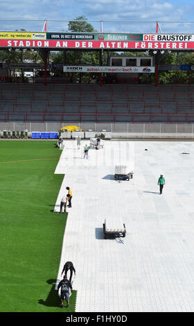 Berlin, Germany. 2nd Sep, 2015. Workers cover the grass field of 1. FC Union's soccer stadium in Berlin, Germany, 2 September 2015. The US rockband Linkin Park will give a concert in the stadium 3 September 2015. PHOTO: SOEREN STACHE/dpa/Alamy Live News Stock Photo