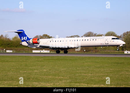 Scandinavian Airlines (SAS) Bombardier CRJ-900 touches down on runway 05L at Manchester airport. Stock Photo