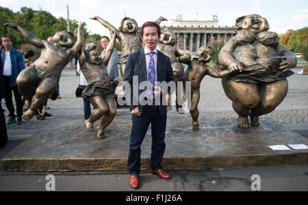 Berlin, Germany. 2nd Sep, 2015. Chinese artist Xu Hongfei poses amidst his open air sculpture's exhibition 'Chubby women' in Berlin, Germany, 2 September 2015. Hongfei's exhibition was opened the same day in the afternoon. Many of his works will be displayed around the city (especially Potsdamer Platz) until 13 September 2015. PHOTO: BERND VON JURTCZENKA/dpa/Alamy Live News Stock Photo