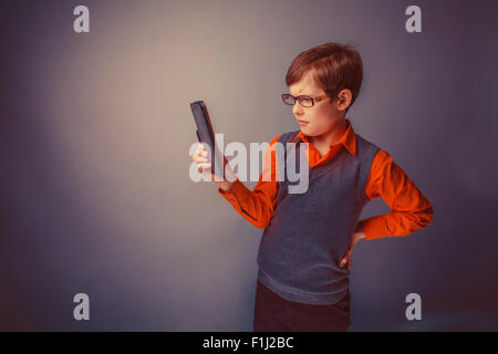 European-looking boy of  ten years in glasses  looks at the plat Stock Photo