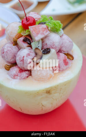 Fresh Fruit Salad with cream sauce in Cantaloupe Bowl Stock Photo