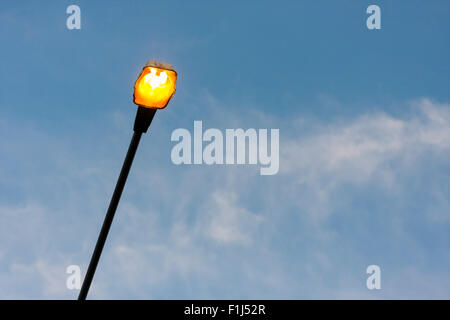Street light turned on early in the evening, blue sky in the background Stock Photo
