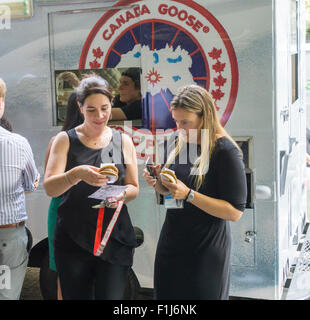 Ice cream lovers line up for a cool treat from the Coolhaus ice cream truck courtesy of the Canada Goose outdoor apparel company on Tuesday, September 1, 2015. The Canada Goose promotion was to promote the launch of their e-commerce site in the U.S. market. Their thousand dollar super-warm parkas were extremely popular and ubiquitous last winter and now you can order them online in the U.S.. (© Richard B. Levine) Stock Photo