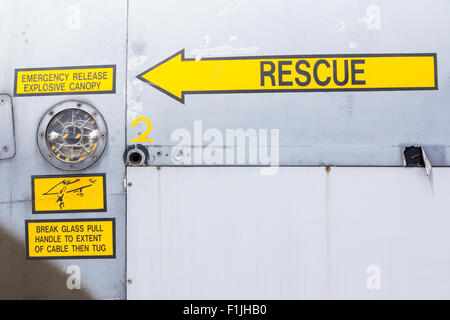 British GR3 Jaguar Fighter. Close up of rescue arrow sign by cockpit with other yellow signs, 'emergency release explosive canopy'. Stock Photo