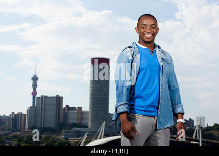 Casually dressed young black man stands in front of cityscape Stock Photo