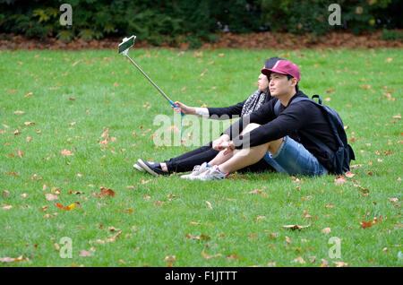 London, England, UK. Young Japanese couple taking a selfie in Victoria Tower Gardens, Westminster Stock Photo