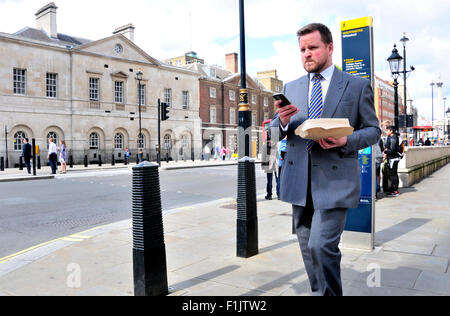 London, England, UK. Man in Whitehall looking at his mobile phone Stock Photo