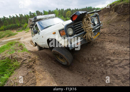 A Toyota 4-wheel drive is driving on a special off the road terrain for land cruisers and vehicles Stock Photo