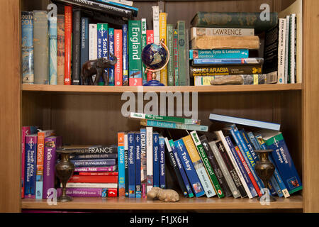Book case with books about travel and adventure. Stock Photo