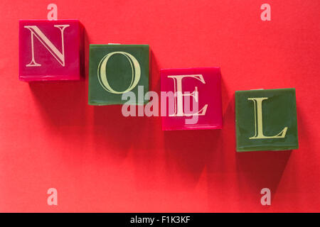 Noel candles 4 four individual square candles for Christmas isolated on red background Stock Photo