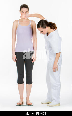 doctor with woman on weighing scale Stock Photo