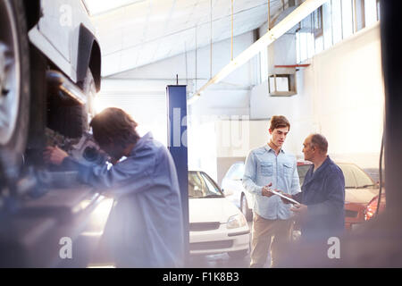 Mechanic speaking with customer in auto repair shop Stock Photo