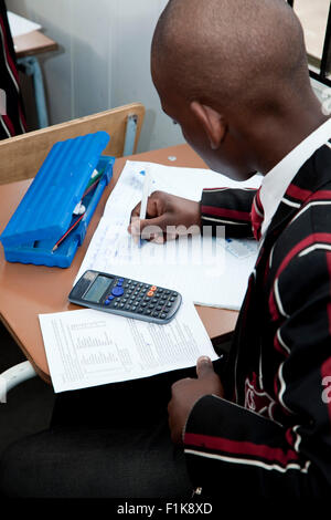 view from behind of a male high school student working at a desk with his calculator Stock Photo