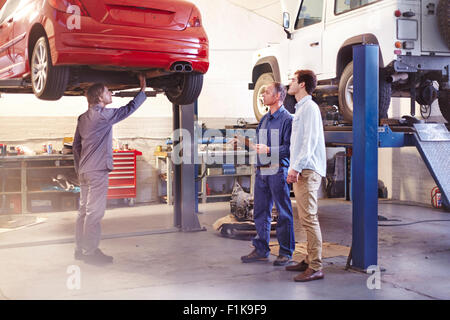 Mechanic talking to customer in auto repair shop Stock Photo