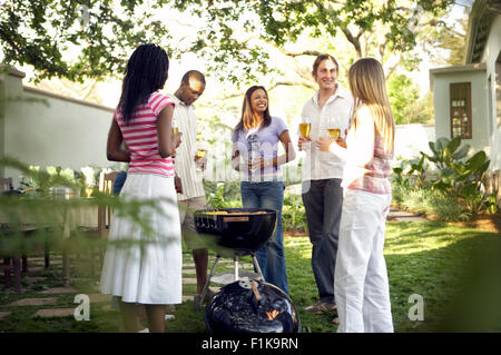 Multicultural group of friends having a braai/barbecue, South Africa Stock Photo