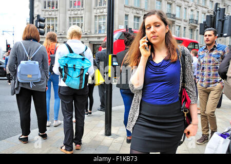 London, England, UK. Young woman on her mobile phone in Oxford Circus Stock Photo