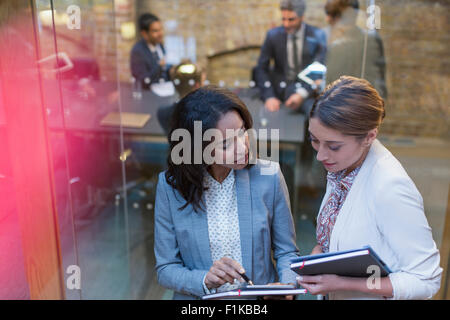 Businesswomen talking outside conference room meeting Stock Photo