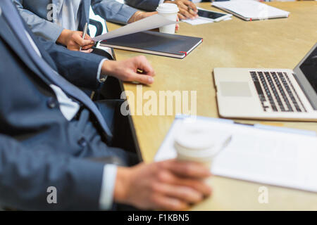 Businessman drinking coffee at laptop in meeting Stock Photo