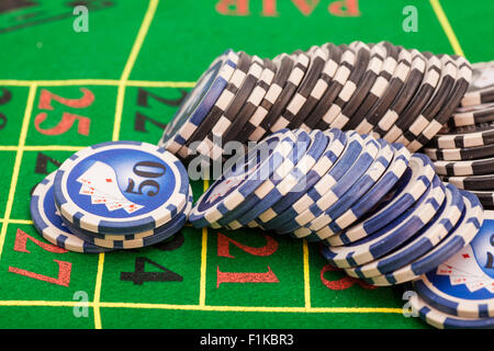 casino chips on  green felt game table in a casino Stock Photo