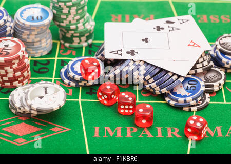 Casino chips, cards and dices on green felt game table Stock Photo