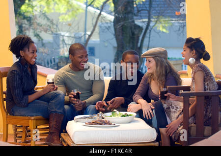 Friends having drinks, laughing Stock Photo