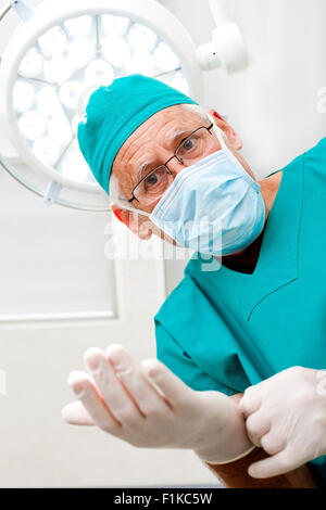 Surgeon putting on medical gloves Stock Photo