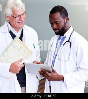 Two doctors going over reports on a tablet Stock Photo