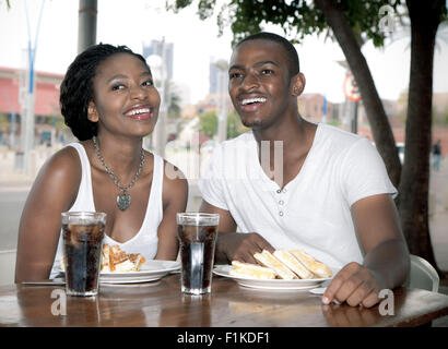 Young African couple sitting at a street-side restaurant, Newtown Johannesburg Stock Photo