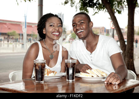 Young African couple sitting at a street-side restaurant, Newtown Johannesburg Stock Photo