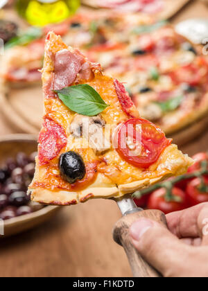 Piece of pizza with mushrooms, ham and tomatoes. Top view. Stock Photo