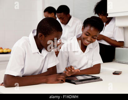Two African teenagers working on a graphics tablet together Stock Photo