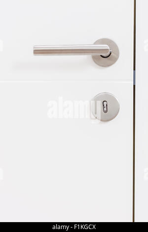 Vertical studio shot of a gray metal handle on a white door Stock Photo