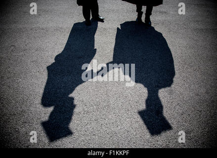 The shadows of two young students on graduation day at University of Birmingham, England. Stock Photo