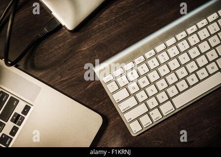 Entrepreneur Work Desk. Modern Working Desk. Laptop Computer, Wireless Keyboard and Portable External Drive. Dark Wooden Desk To Stock Photo