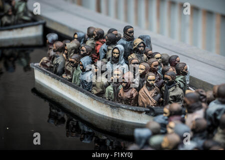 Street artist Banksy's Dismaland in Weston-Super-Mare. Pictured is piece featuring radio controlled boats packed with migrants. Stock Photo