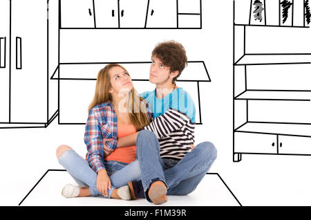 Portrait of attractive young happy couple in love man and woman isolated over white background sitting on floor looking up while dreaming with furniture sketch Stock Photo