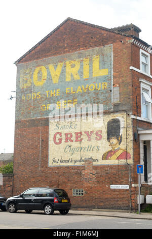 Vintage large painted advertising signs for Bovril beef drink and Greys cigarettes on wall in Bedford, Bedfordshire, England Stock Photo