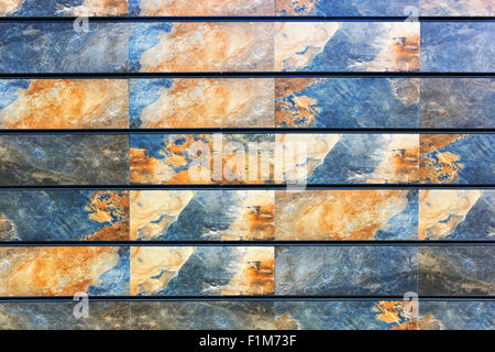 The wall is fixed by rectangular stone plates with yellow blue space drawing of texture. Real nature backgound Stock Photo
