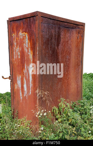 Lonely broken  rusty safe in the wood on a green glade. Isolated Stock Photo