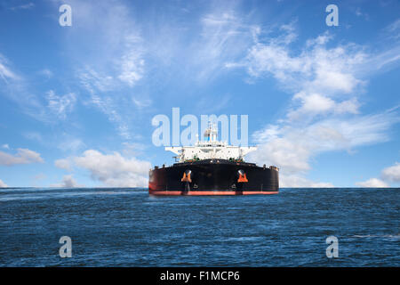 Oil tanker ship at sea on a background of blue sky. Stock Photo